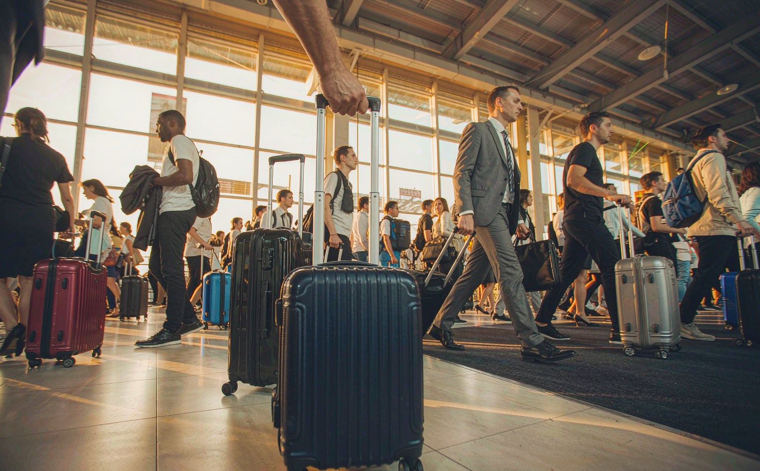 Travelers pulling suitcases through a busy airport during Golden Week